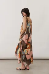 Vestido midi de tirantes ajustables con lazo en los hombros, escote en V y diseño amplio con estampado floral abstracto en tonos marrones, rosados, celestes y amarillos.