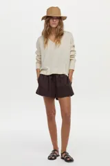 Sweater de punto con escote en V y mangas cortas, confeccionado con hilo metalizado con lurex, de calce cómodo y holgado.