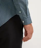 Camisa de corte slim con estampado de cuadros pequeños en tonos azul y verde. Presenta cuello camisero, cierre frontal con botones y mangas largas con puños abotonados.