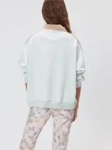 Buzo de algodón con cuello alto y cierre frontal parcial. Presenta bolsillos laterales con cierre y cuello con interior en contraste. Diseño de corte oversize.