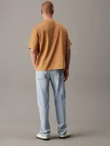 Remera color caramelo de corte holgado, confeccionada en 100% algodón. Tiene mangas cortas, cuello redondo y un bolsillo de parche en el pecho con etiqueta de la marca.