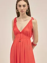Vestido largo de crepe color rojo, con escote en V profundo, breteles finos ajustables con nudos y detalle de cordón ajustable en la cintura con terminales metálicas.