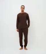 Pijama masculino de dos piezas confeccionado en tejido fleece texturizado. Incluye una remera de manga larga con cuello redondo y puños ajustados, y un pantalón tipo jogger con cintura elástica, cordón de ajuste y bolsillos laterales.