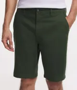 Bermuda masculina de corte slim, confeccionada en sarga de algodón con un toque de elastano. Presenta un diseño liso con cierre de botón y cremallera, cintura con trabillas para cinturón y dos bolsillos laterales.