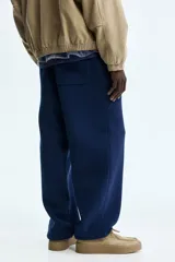 Pantalón deportivo azul marino confeccionado en felpa de mezcla de algodón, con cintura elástica ajustable, bolsillos laterales y bajos con elástico fruncido.