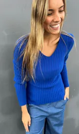 Sweater de punto color azul eléctrico, con escote en V, mangas largas con puños lisos y diseño acanalado.