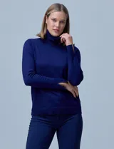 Polera de tejido fino color azul, con cuello alto, manga larga y detalle de tajo en los puños.
