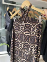 Vestido largo de corte recto con estampado abstracto en tonos marrón y beige, cuello halter y espalda descubierta.