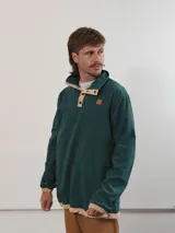 Buzo de pana color beige con cuello polo abotonado y bolsillo en el pecho.