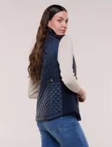 Chaleco acolchado de diseño entallado color beige, con matelaseado en patrón de rombos en frente y espalda, cuello alto estructurado y cierre frontal completo con cremallera metálica y ribete a contraste.