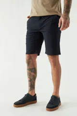 Bermuda tipo chino de gabardina con cierre de cremallera y botón, bolsillos laterales y traseros, y pasacintos en la cintura.