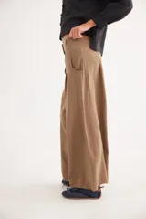 Pantalón de tiro alto en color azul, con cierre frontal de tres botones, pinzas en la cintura y corte holgado.