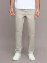 Pantalón de corte slim confeccionado en mezcla de algodón y elastano. Presenta un diseño clásico de cinco bolsillos, cierre con botón y cremallera, y detalles distintivos de la marca.