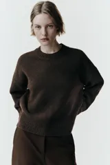Jersey de cuello redondo y manga larga, confeccionado en tejido de punto suave con acabados en rib en cuello, puños y bajo.