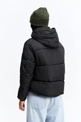 Campera puffer negra con cuello alto, cierre frontal y bolsillos laterales con cierre. Diseño acolchado de volumen medio.