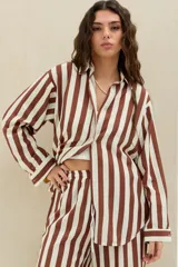 Camisa de manga larga con estampado de rayas verticales en color marrón y blanco, con cuello clásico y cierre frontal de botones.