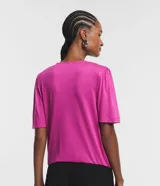 Blusa fucsia de viscolycra crepada, con escote en V y mangas cortas con detalle de pliegues en los hombros.