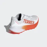 Championes de trail running Adidas Terrex Agravic 3 en color blanco con detalles en naranja. Presentan una mediasuela Lightstrike para amortiguación dinámica, suela de caucho Continental™ con perfil dentado para tracción en senderos y exterior textil transpirable con refuerzos sintéticos resistentes a la abrasión.