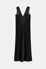 Vestido midi de viscosa color negro con escote en V y aplicaciones de encaje a tono en los tirantes y el pecho, de silueta evasé.