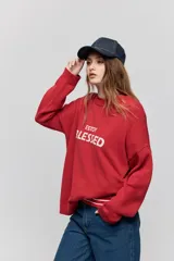 Sweater de punto marrón de tejido liviano y calce relajado, con hombros caídos, cuello redondo y puños y cintura en rib. Cuenta con una estampa tejida en el frente con la frase "Estoy Blessed" en color amarillo.