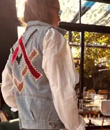 Chaleco de jean celeste con apliques geométricos en terciopelo rojo y negro, bordados a mano.