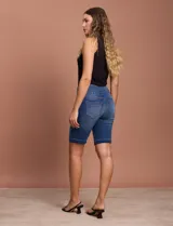 Bermuda de jean azul con pretina ancha elastizada, bolsillos delanteros y traseros, y ruedo con dobladillo.