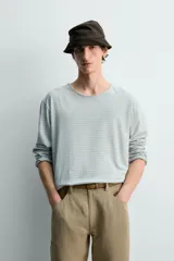Camiseta de manga larga con ajuste relaxed fit y cuello redondo amplio, confeccionada en tejido de mezcla de algodón y lino con patrón de rayas horizontales en color verde y blanco.