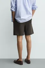 Bermuda regular fit azul marino confeccionada en lino, con bolsillos frontales, bolsillos traseros de doble vivo con botón y cierre frontal con cremallera y botón.