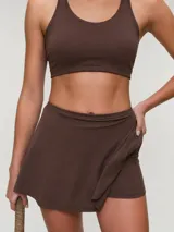 Falda short deportiva de color marrón, con calza interna y bolsillo lateral.