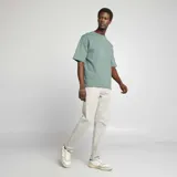 Pantalón chino slim color gris claro, con cinco bolsillos y cierre de botón y cremallera.