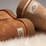 Botas cortas UGG Classic Mini II color marrón claro, confeccionadas en gamuza con interior de piel de oveja.