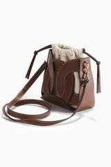 Cartera bombonera combinada de cuero sintético marrón con pespuntes blancos y bolsa interior de lona de mezcla de algodón y lino. Cuenta con diseño estructurado, cierre ajustable con cordón y correa bandolera extraíble con mosquetones metálicos dorados.