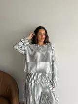 Conjunto compuesto por remera de manga larga y pantalón largo, confeccionados en tejido rib con diseño de rayas horizontales.