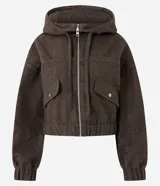 Campera tipo bomber color marrón oscuro, con capucha, cierre frontal de cremallera, bolsillos delanteros con solapa y puños elásticos.