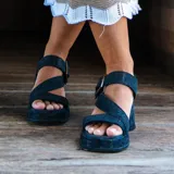Sandalias de cuero color negro con plataforma, taco ancho y tiras cruzadas en el empeine con hebilla ajustable.