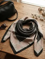 Pañuelo cuadrado de satén con estampado geométrico en tonos negro y beige, con borde decorativo.