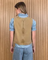 Chaleco marrón de denim con pespuntes en contraste, cuello redondo y cierre frontal con botones.