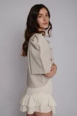 Blusa de lino con mangas abullonadas, escote en V y cierre frontal con botones. Presenta delicados bordados a mano dispersos por toda la prenda.