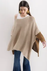 Poncho de tejido de punto con diseño oversize, cuello amplio y tajos laterales. Presenta una combinación de colores en tonos beige y marrón con acabado brillante.