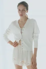 Saco corto en punto fino suave de mezcla de viscosa. Modelo entallado con cuello en V y cierre de botones. Remate acanalado ancho en puños y bajo.