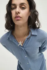 Collar de cadena fina con dije central en forma de estrella de mar, bañado en plata.
