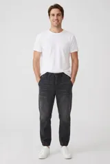 Pantalón jogger gris oscuro con efecto gastado, cintura elástica con cordón de ajuste y puños elastizados en los tobillos.