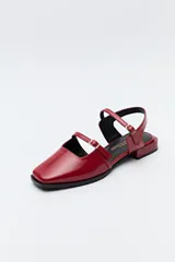 Zuecos destalonados color crema, de símil cuero, con punta cuadrada y finas tiras con hebillas ajustables. Cuentan con taco de 2,5cm de alto.