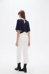 Pantalón jean blanco de corte recto y tiro alto con terminación deshilachada en el Isodelo.
