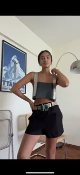 Top corto de ecocuero negro con tirantes anchos y espalda ajustable.