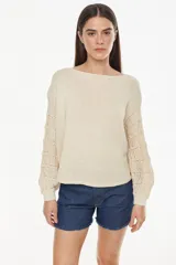 Sweater cropped de punto calado, color celeste melange, con mangas anchas de diseño holgado y cuello redondo.