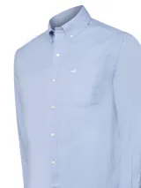 Camisa de vestir de hombre de manga larga, color celeste claro, con cuello button-down y bolsillo en el pecho. Presenta un pequeño logo bordado en el bolsillo.