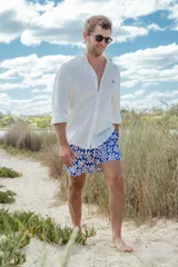 Short de baño azul con estampado floral blanco y amarillo.