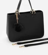 Bolso satchel negro con correa de mano fija y correa bandolera desmontable. Incluye llavero de pompón.