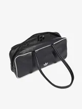 Bolso tipo shopper de diseño alargado, confeccionado en material sintético texturizado color negro con ribetes blancos. Presenta doble asa larga para llevar al hombro, cierre superior con cremallera y el logo del trébol de Adidas estampado en el frente.